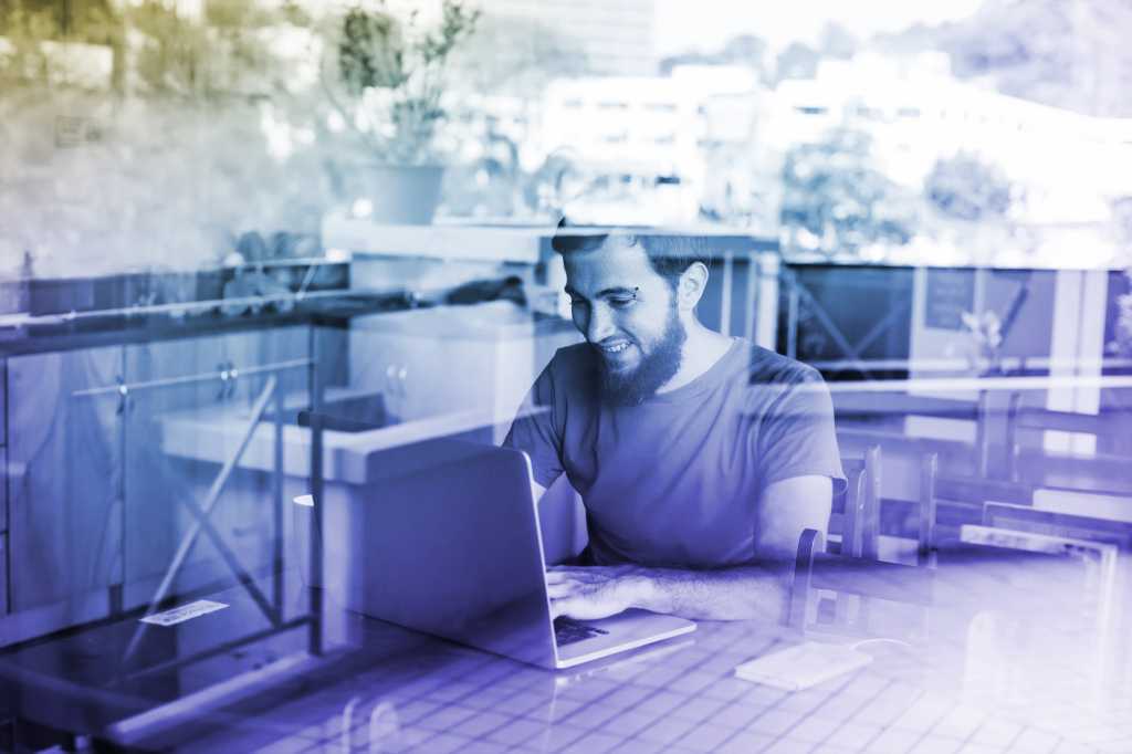 developer programmer seated at desk in front of window