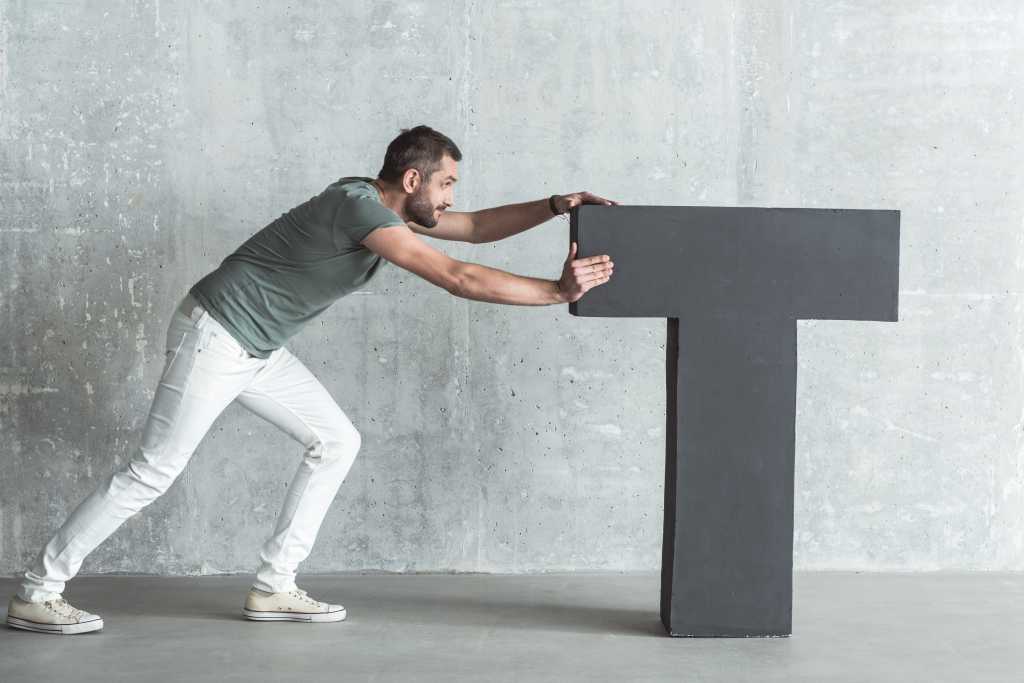 A young man pushes the letter t to the center of the screen.