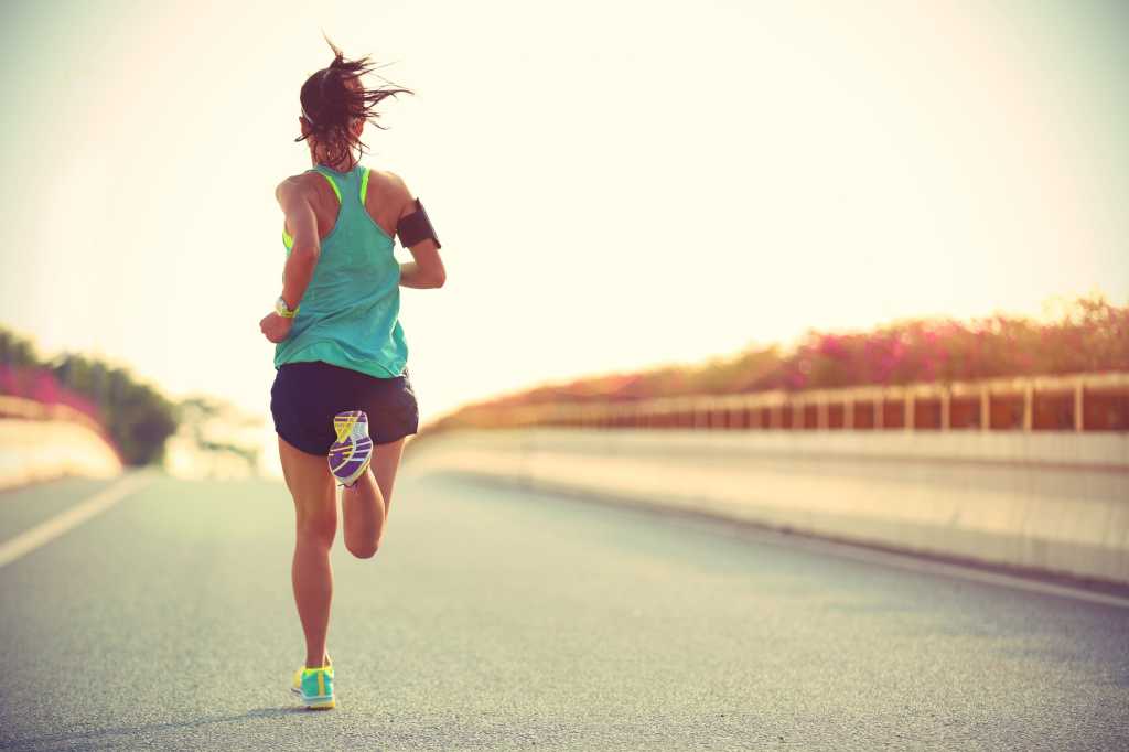 A woman running down an empty road.