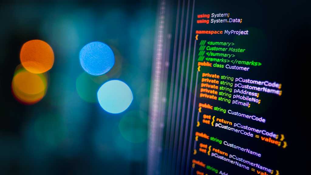 C# programming language C sharp source code example on monitor and bokeh background.